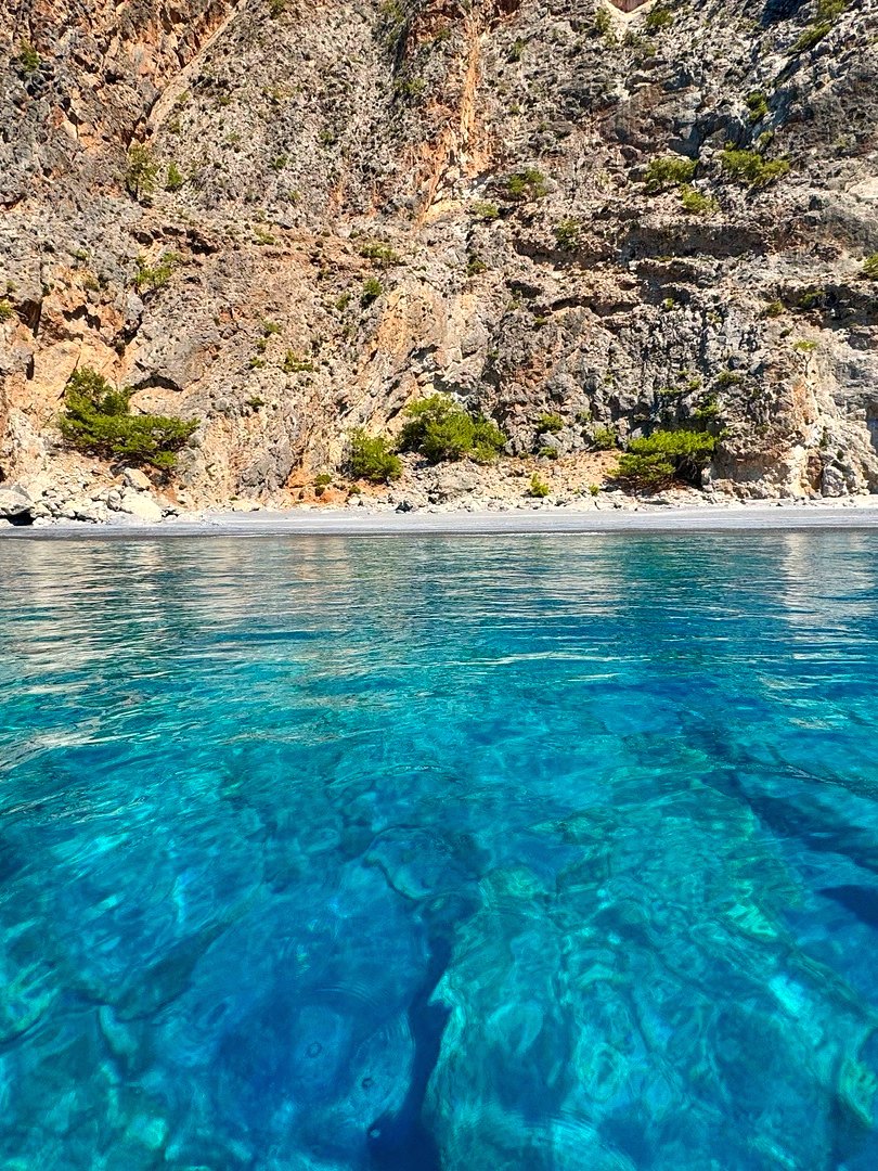 Turquoise cove beneath cliffs, Crete